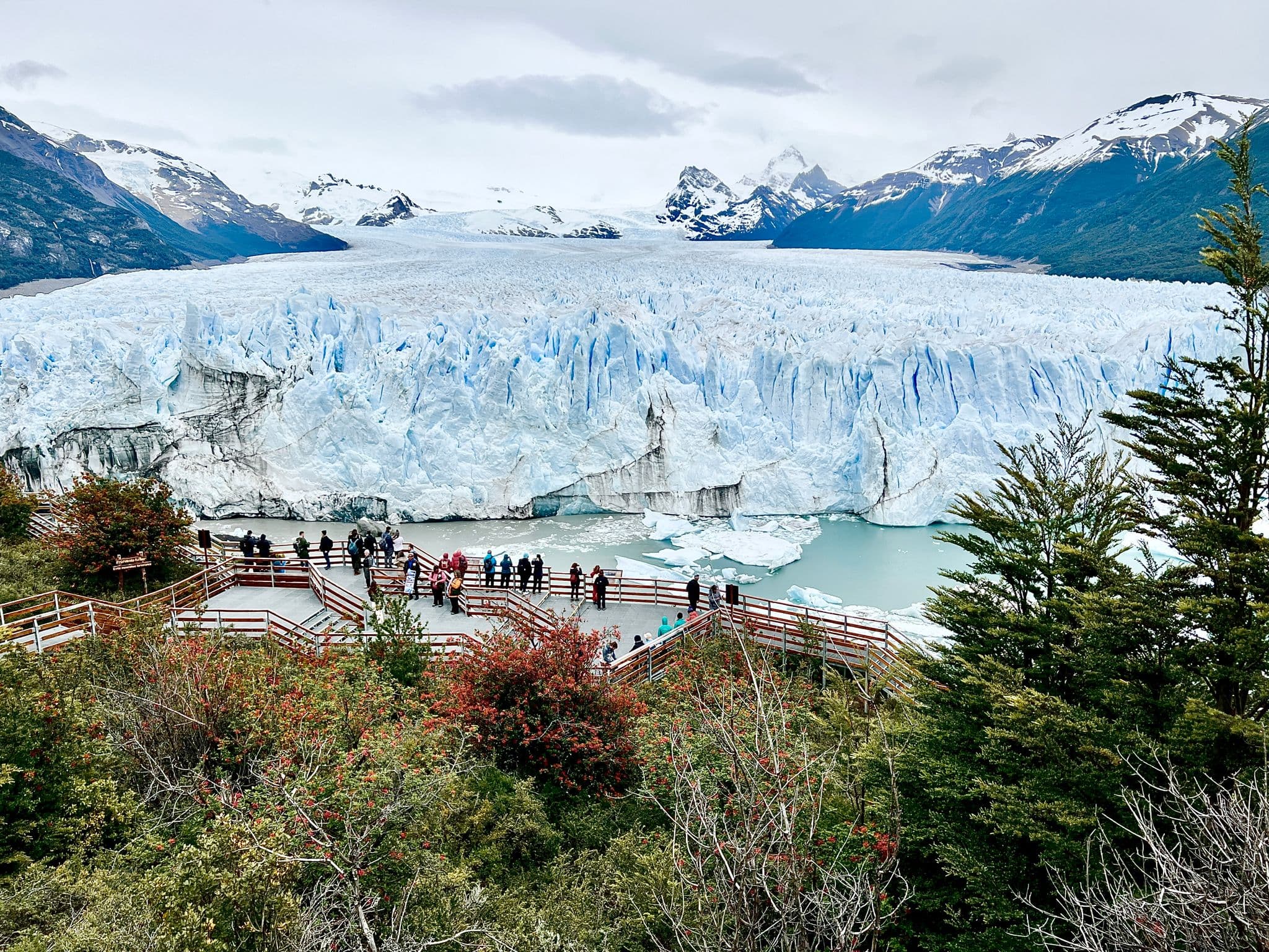Perito Moreno Glacier filling the view with visitors on wooden viewing platforms in Los Glaciares National Park, Argentina.