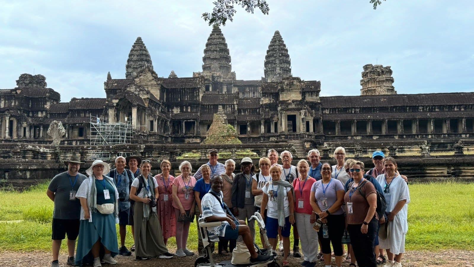 Angkor Wat temple with a tour group posing in front on a trip near Siem Reap, Cambodia.
