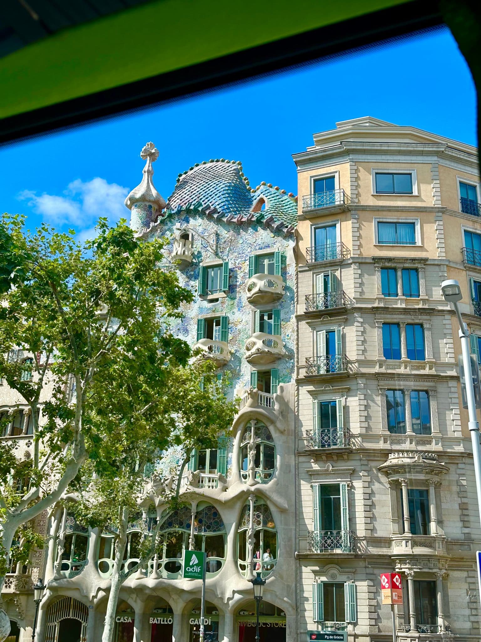 Casa Batlló's mosaic facade and Gaudí-style balconies seen from the street on Passeig de Gràcia, Barcelona, Spain.