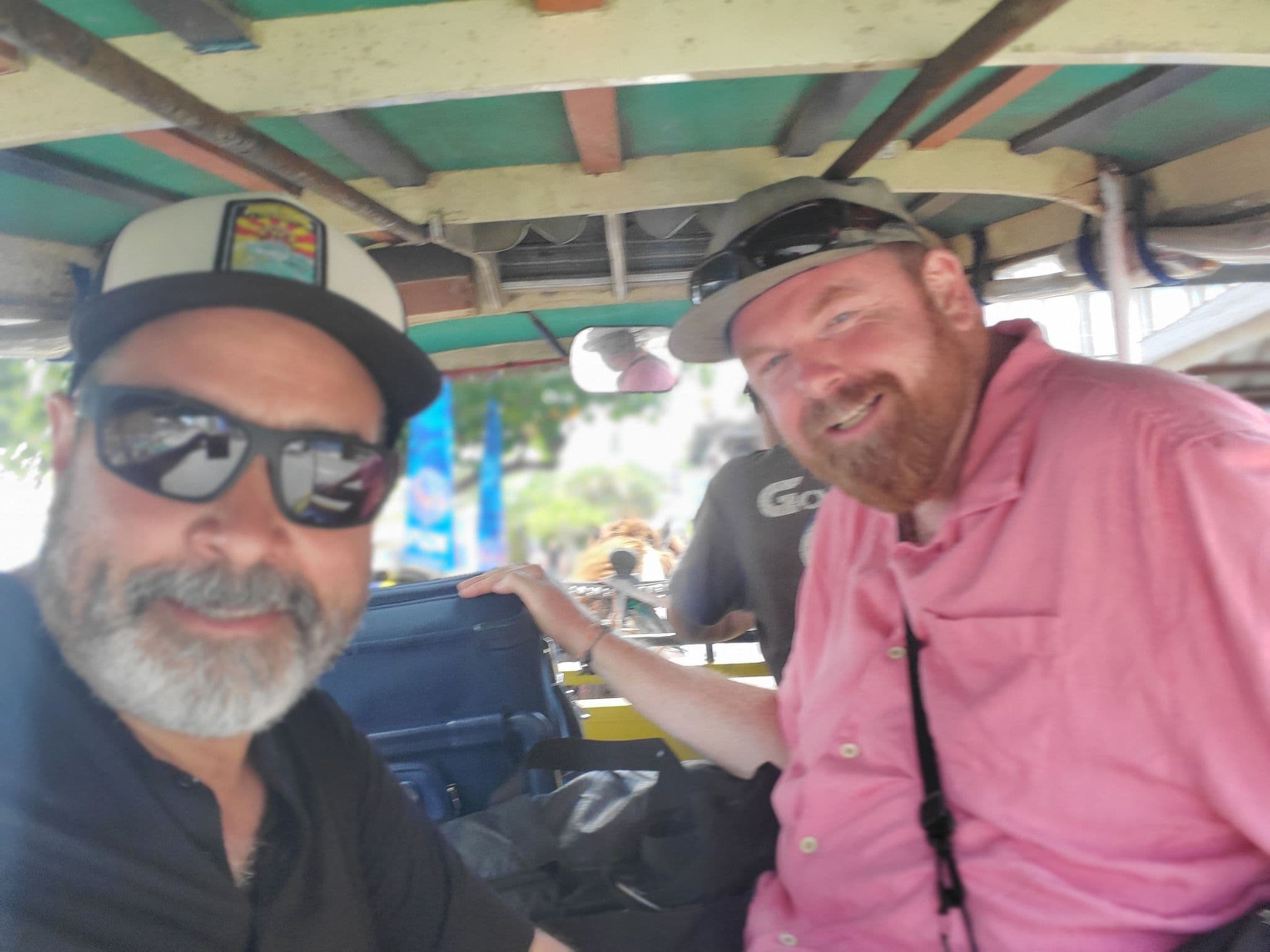 Two men smiling inside a cidomo (horse-drawn carriage) on Gili Trawangan, Indonesia.