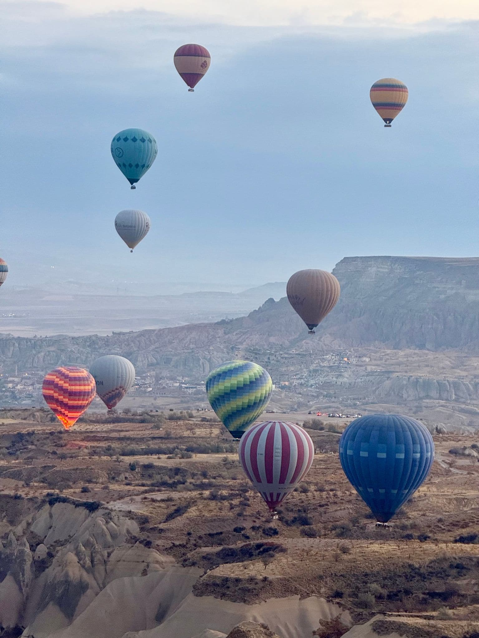 Hot air balloons floating over the rocky valleys of Cappadocia, Turkey.
