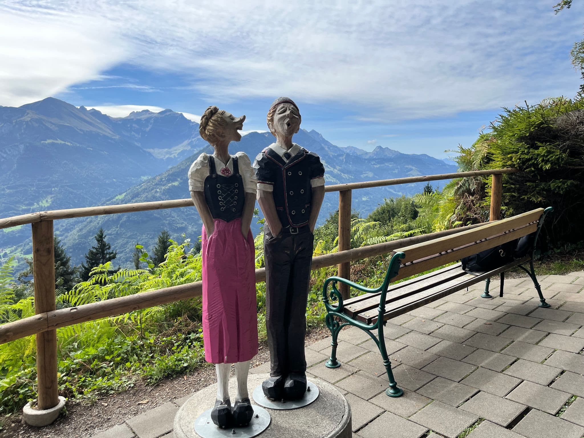 Harder Kulm viewpoint in Interlaken, Switzerland with two carved singing statues overlooking the Bernese Alps.
