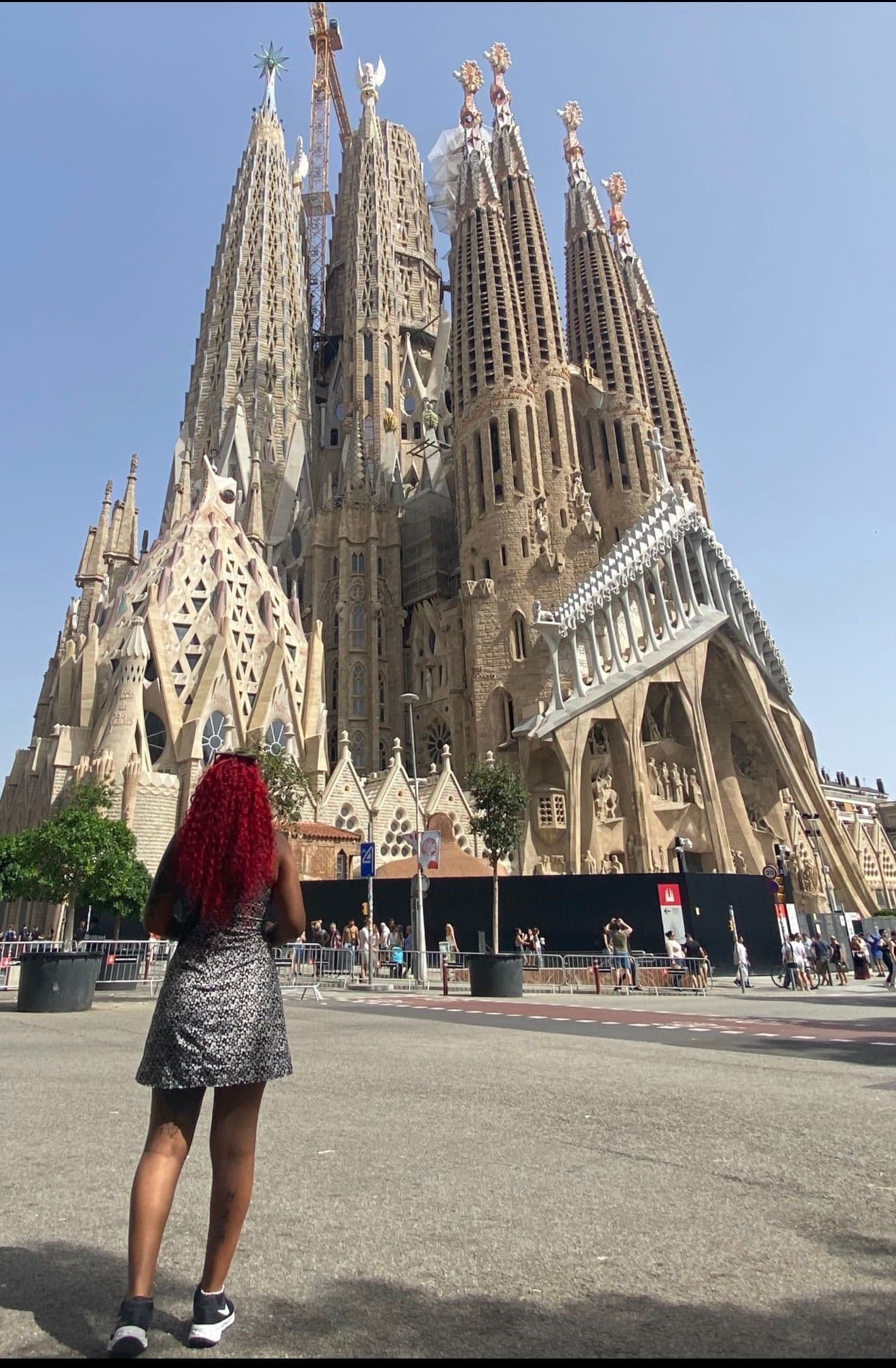 Sagrada Família basilica in Barcelona with a traveler standing in the foreground looking up, Spain.