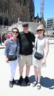 Basílica de la Sagrada Família in Barcelona with three travelers posing in front on a sunny day