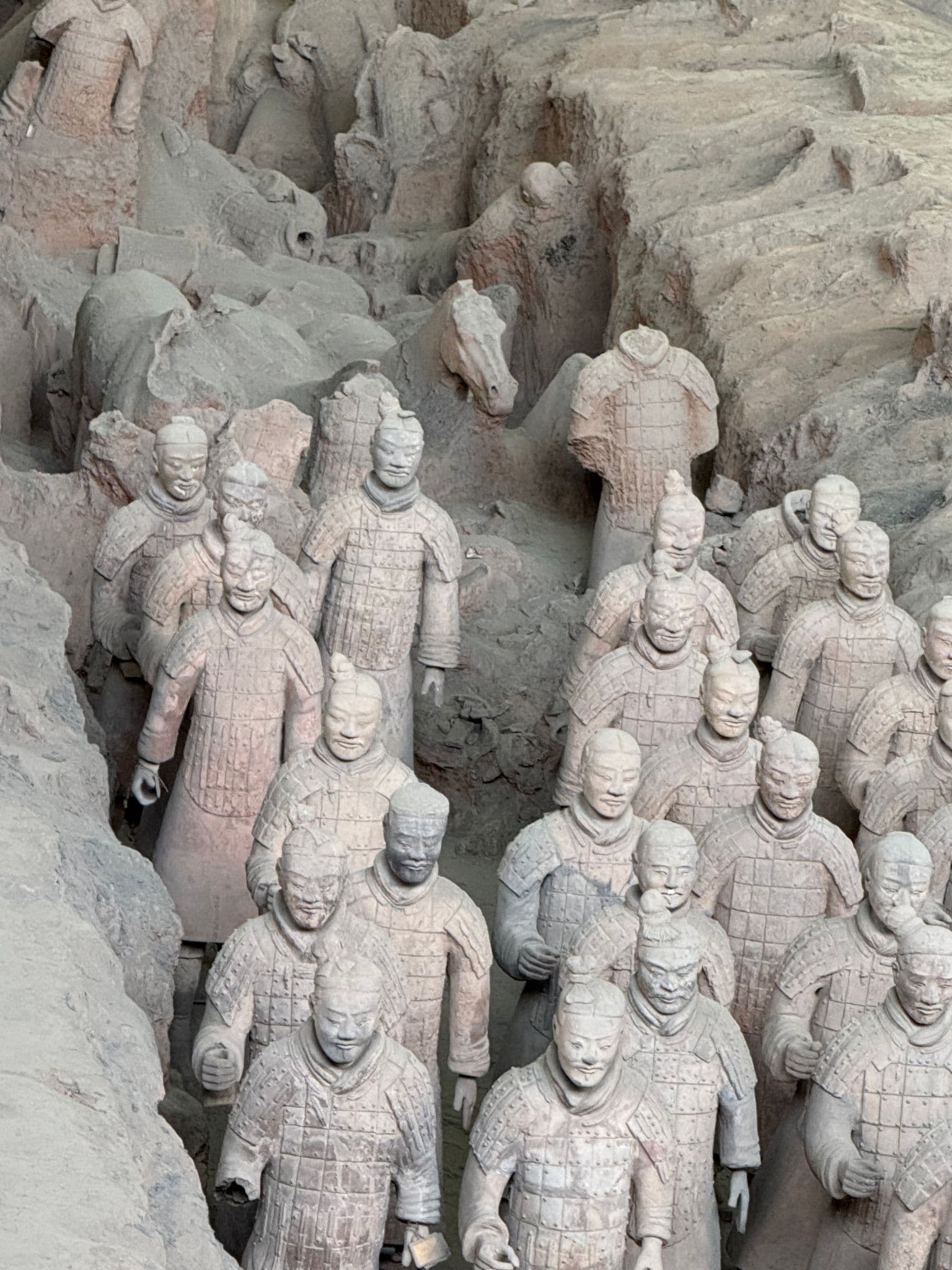 Rows of life-size Terracotta Army soldiers standing in excavated pits at the Mausoleum of the First Qin Emperor, Xi'an, China.