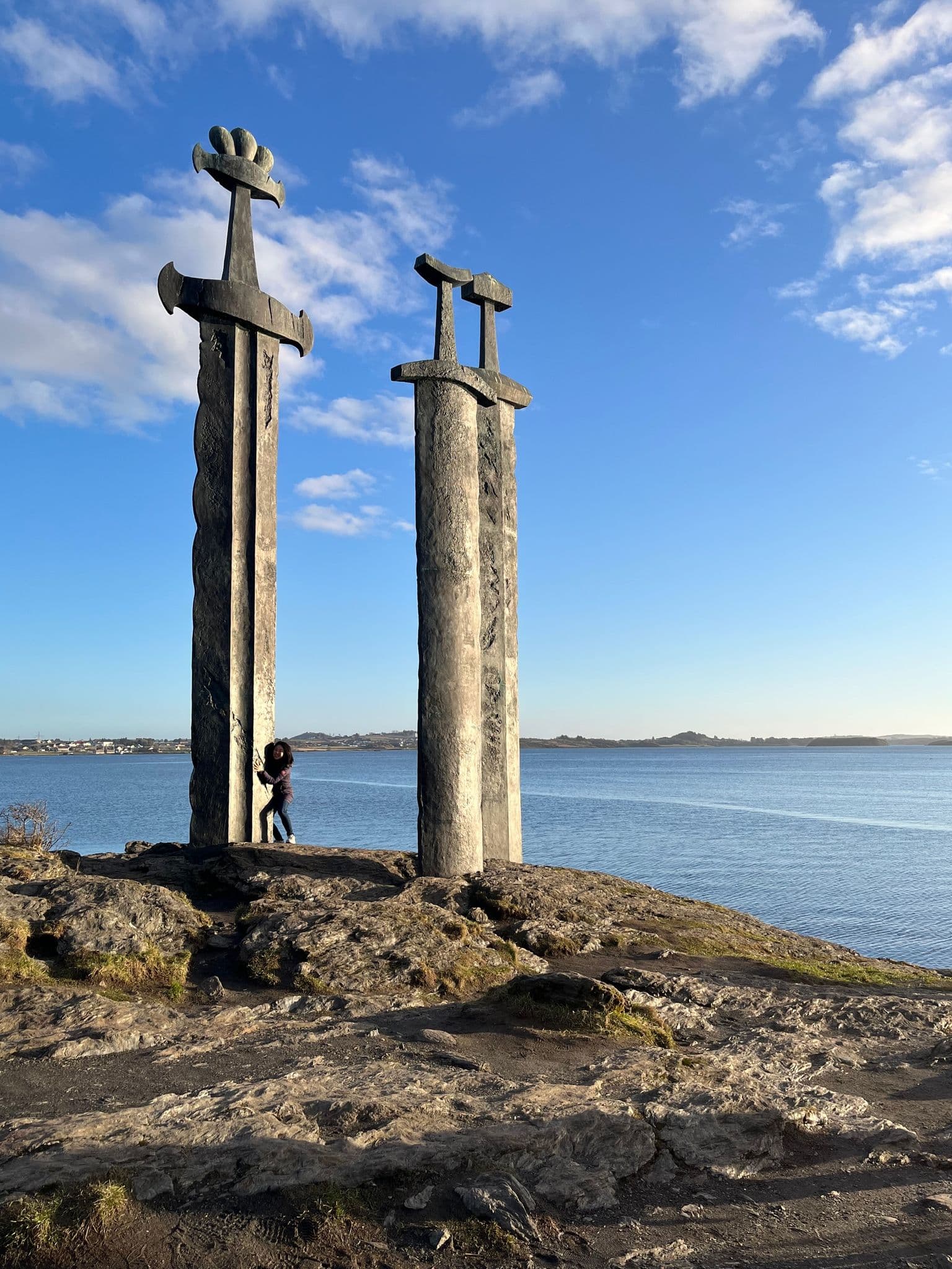The Sverd i fjell (Three Swords) monument at Hafrsfjord near Stavanger, Norway, a person leaning on one sword by the sea.