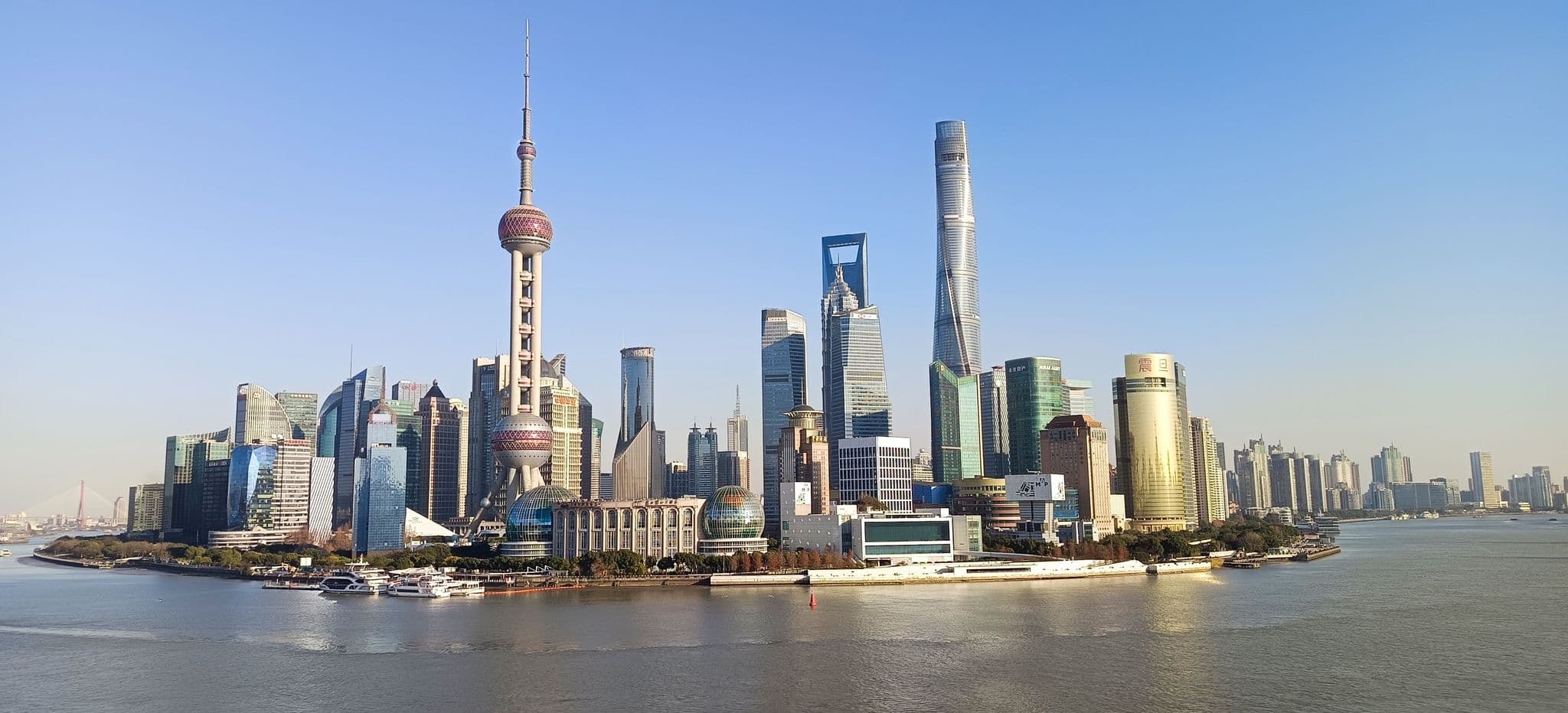 Oriental Pearl Tower and Pudong skyline across the Huangpu River, Shanghai, China, seen from a rooftop bar.