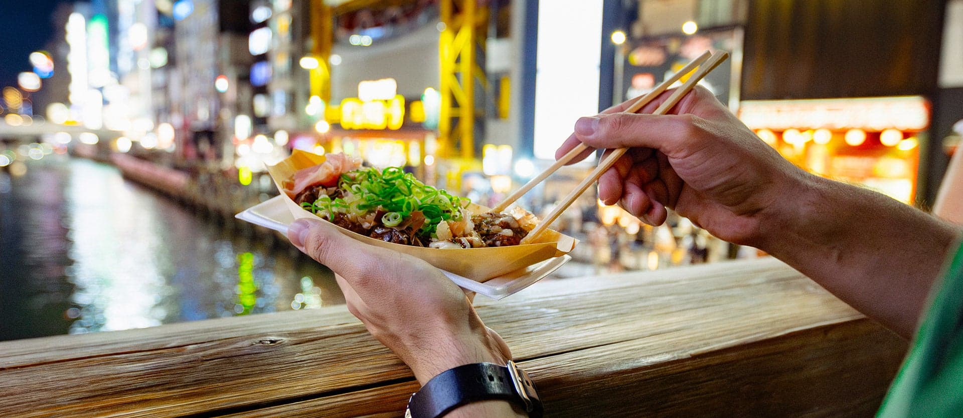 A tourist eating a takoyaki ball <span class="iconos separador"></span> Osaka